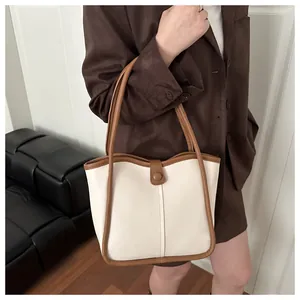 Detalle de bolso tote de cuero bicolor en modelo con correas de hombro finas