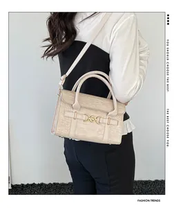 Detailed view of cream crocodile-embossed handbag with gold heart horsebit buckle