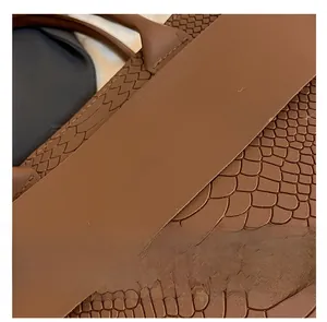 Close-up of brown crocodile pattern leather tote bag with gold fashion lettering