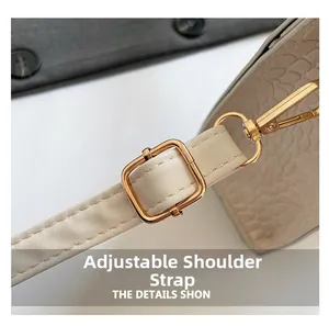 Macro shot of adjustable shoulder strap with gold buckle and crocodile texture detail