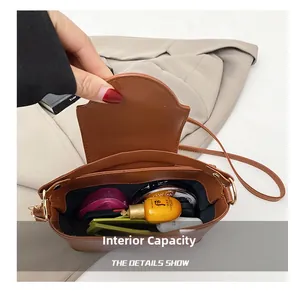 Detail view of the brown bucket bag showing the spacious interior and black lining