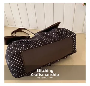 Detailed view of meticulous stitching craftsmanship on the vintage polka dot tote bag base