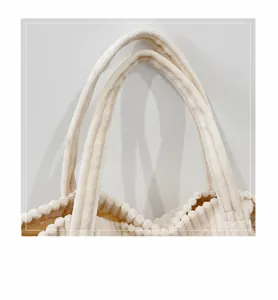 Detail of comfortable corduroy handle and beige plush texture on oversized tote bag