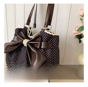 Close-up of retro polka dot tote bag with leather bow and delicate lace trim detail