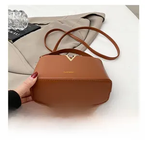 Detail of the wear-resistant bottom on this brown leather bucket bag with V-shaped metal trim