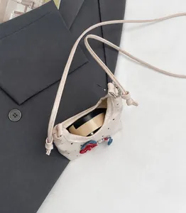 Detailansicht der rosa Mini-Tasche mit herzförmigem Laserschnitt und Blumenstickerei