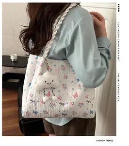 Close-up of quilted floral tote bag with woven strap and cloud charm detail