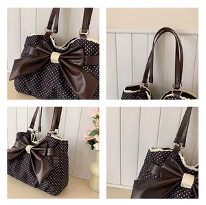 Detail of canvas tote featuring polka dots, large leather bow, and delicate lace trim