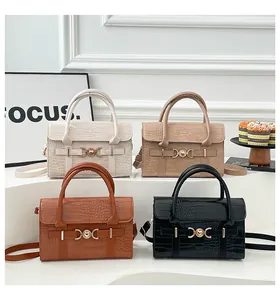 Detail view of crocodile pattern leather handbags with golden heart buckles in four colors