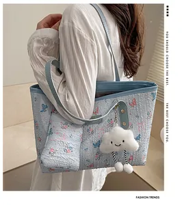 Dettaglio borsa shopper floreale azzurra con tessuto a bolle e ciondolo a nuvola