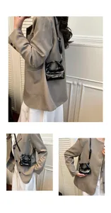 Detail view of mini black glossy patent leather handbag with Fashion text and silver buckle