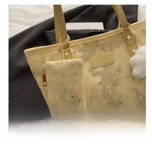 Detail view of yellow tote bag set with starry patterns and branded leather label