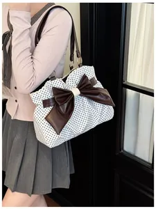 Close-up of polka dot tote bag with large leather bow and vintage metal ring handle