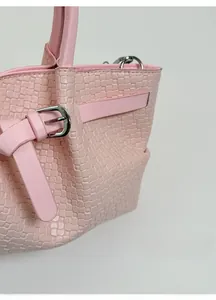 Detailed view of pale pink bucket bag featuring woven texture and silver buckle strap