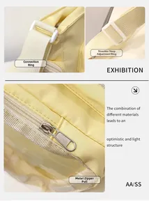 Detail of adjustable strap rings and metal zipper on cream yellow nylon shoulder bag