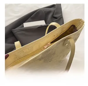 Detail showing smooth light gold metal zipper on yellow tote bag with star moon patterns