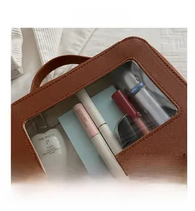 Détail de trousse de toilette en cuir marron avec fenêtre transparente et zip doré