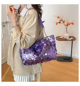 Détail du sac à paillettes violettes avec chaîne dorée sur mannequin en trench-coat