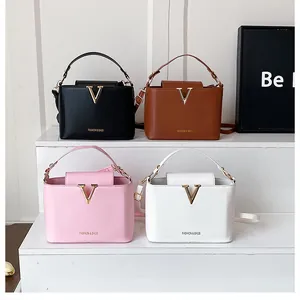 Minimalist bucket bags in black, brown, pink and white with gold V-shape metal hardware
