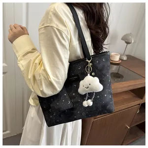 Black tote bag with silver star and moon patterns featuring a white cloud plush charm