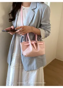 Pink woven texture bucket bag styled with a light blue blazer and white skirt outfit