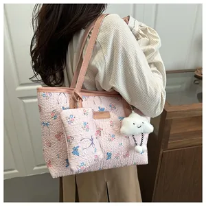 Dettaglio della borsa tote floreale con pochette coordinata e ciondolo a nuvola