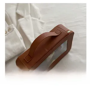 Détail de la trousse de maquillage en cuir marron avec fenêtre PVC et fermeture dorée