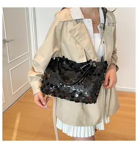 Détail d'un sac cabas à paillettes noires avec chaîne dorée et fini brillant