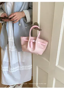 Detail of pink woven leather bucket bag with metallic buckle and retro minimalist texture