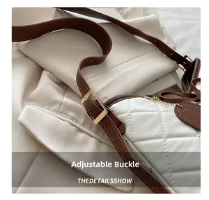 Macro detail of adjustable golden buckle on white quilted leather shoulder bag strap