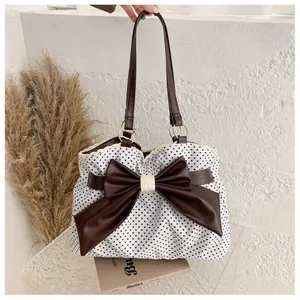 Detailed view of polka dot tote bag with large leather bow and lace edge trim