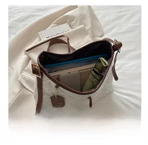 Interior view of large quilted tote bag showing storage for tablet, phone and umbrella