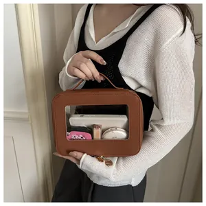 Détail de la trousse de toilette marron avec fenêtre transparente et zip doré poli