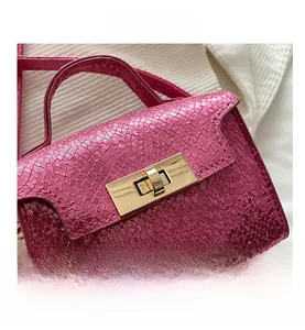 Close-up of metallic rose pink faux snake skin texture and gold square turn-lock closure