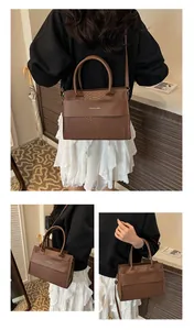 Detailed close-up of dark brown crocodile embossed texture on a chic women's tote bag