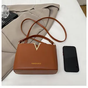 Detailed top view of a brown leather bucket bag with golden V logo and metal accents