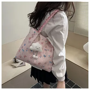 Detail of pink floral tote with butterfly print and fluffy cloud charm attachment