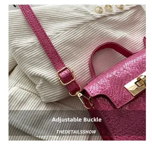 Detailed close-up of the adjustable golden metal buckle on a pink snakeskin mini bag