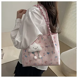 Detail of floral tote bag with blue ribbon bow and fluffy cloud charm accessory