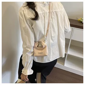 Mini glossy handbag with 'FASHION' text shown being worn as a stylish crossbody bag