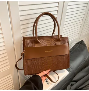 Dettaglio della borsa marrone in ecopelle con texture a coccodrillo e scritta dorata