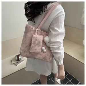 Pink tote bag detail with star moon patterns, mini coin purse and cloud plush charm