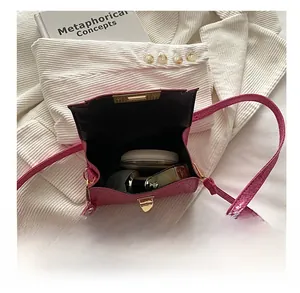 Interior view of the rose pink patent leather bag showing capacity for cosmetics