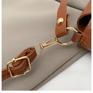 Close-up of premium gold hardware and lychee grain leather on a caramel bucket bag