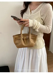 Detailed close-up of brown woven leather texture and elegant metallic buckle on the bag