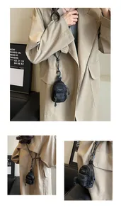 Detail view of mini black nylon shoulder bag with adjustable lanyard and zipper pocket