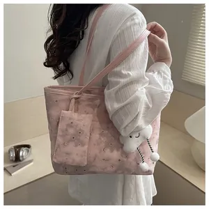 Detailed side view of pink canvas tote bag with star patterns and plush cloud charm