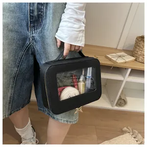 Détail de la trousse de toilette noire avec fenêtre en PVC et détails de fermeture dorés