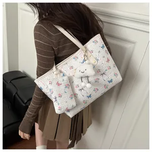 Dettaglio della borsa tote floreale con pochette abbinata e ciondolo a nuvola