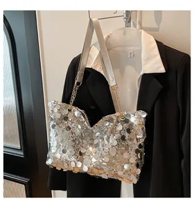Détail des paillettes argentées et de la chaîne dorée sur un sac cabas élégant et moderne